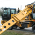 A Gradall Highway Speed Wheeled Excavator digs at the side of a road.